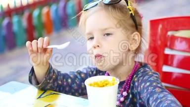 小女孩在夏季公园吃街头美食玉米，旅游美食概念
